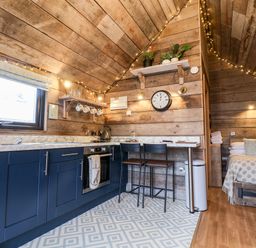 A kitchen and bedroom area with wooden walls and ceiling at Sunset Retreat in Seamer North Yorkshire