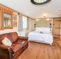 A bedroom with a bed and leather sofa and Egyptian themed decor at The Egyptologist in Bolton Percy near Tadcaster