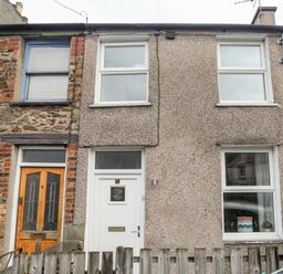 A front view of two adjacent terraced houses with different exterior wall finishes and windows at 5 Thomas Street in Llanberis
