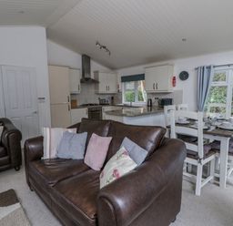 A living room with a sofa and dining area at Seacroft in Stepaside near Kilgetty