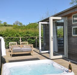 An outdoor area with a hot tub and seating at 7 Valley View, Lanreath