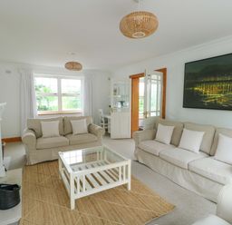 A living room with a sofa and coffee table at Bwthyn Clai in Llangefni