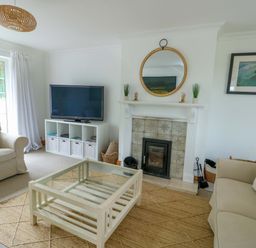 A living room with a television and fireplace at Bwthyn Clai in Llangefni