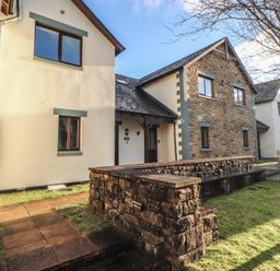 A house exterior with a stone wall and pathway at Mallard Cottage Penrith