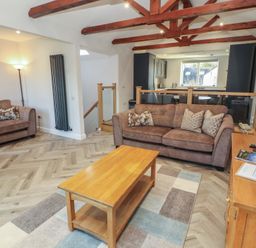 A living room with seating arrangements and a coffee table at Mallard Cottage in Penrith