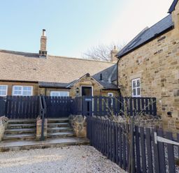 Stone cottages with slate roofs and black wooden fences at Ash Cottage in Lucker near Warenford
