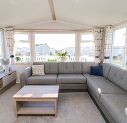 A living room with a grey sectional sofa a wooden coffee table and a tv on a stand at 17 Summer Meadows in Ashington