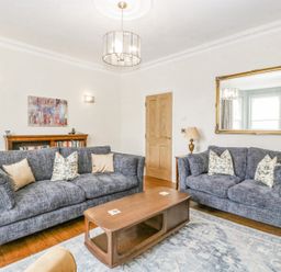 A living room with two grey sofas a wooden coffee table a large wall mirror and a bookshelf at Belle Vue in Hay on Wye Herefordshire