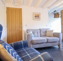 A living room with a sofa and armchair at Ael Y Bryn in Ffestiniog