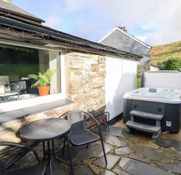 An outdoor area with a hot tub and seating at Ael Y Bryn Ffestiniog