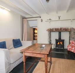 A living room with a sofa and fireplace at Penvar in Truro