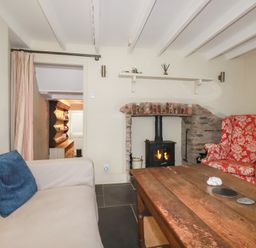 A living room with a fireplace and seating area at Penvar in Truro