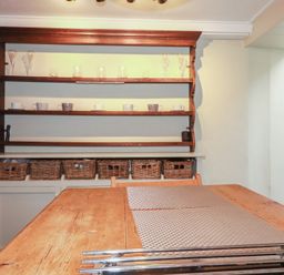 A kitchen with shelves and a wooden table at Penvar in Truro