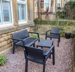 An outdoor seating area with black chairs and a table at Rose House in Alnmouth