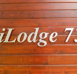 A wooden wall with the text iLodge 73 at iLodge 73 Kenwick near Louth