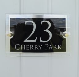 A house number sign showing 23 Cherry Park on a white door at 23 Cherry Park in Chapel St Leonards