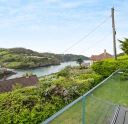 A coastal view with houses trees and a body of water bordered by hills at Beach View in Combe Martin