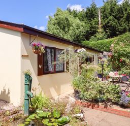 A house with a garden featuring a table and chairs at Turnpike Lodge in Brixham
