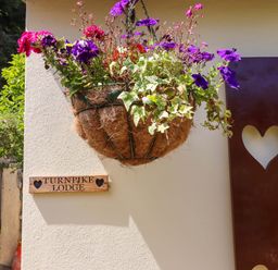 A flower basket and sign at Turnpike Lodge in Brixham