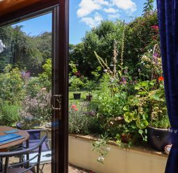 A view of a garden from a dining room window at Turnpike Lodge in Brixham
