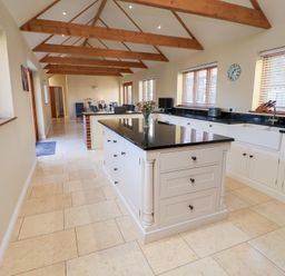 A kitchen with an island and cabinets at The Stables at Hall Barn Wattisfield near Walsham-Le-Willows