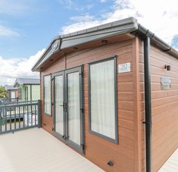 An exterior view of a wooden cabin with glass doors and windows on a deck at 20 Wolds View East Heslerton near West Heslerton
