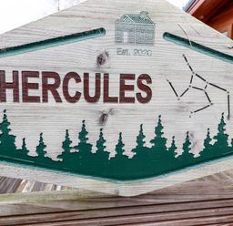 A wooden sign with the word Hercules and tree silhouettes at Hercules in Felmoor Park