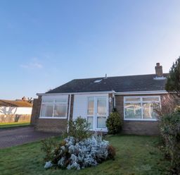 A single story house with a driveway and front garden at Barnacles in Boulmer near Longhoughton