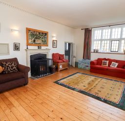 A living room with sofas a fireplace a rug and a large window at Wick Court Farm Arlingham near Frampton On Severn