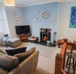 A living room with furniture and fireplace at Riverdance Cottage in Lyme Regis