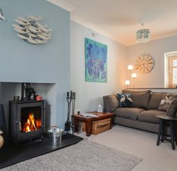 A living room with a sofa and fireplace at Riverdance Cottage in Lyme Regis
