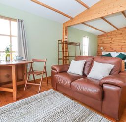 A living room with a couch and dining table at Lodge 1 in York
