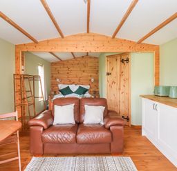 A living room with a sofa and dining area at Lodge 1 in York