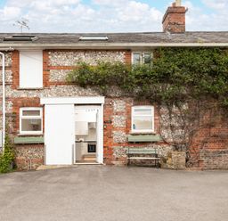 An exterior view of a building with a door leading to a kitchen at Stable in Blandford Forum