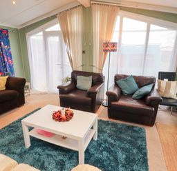 A living room with sofas and a coffee table at Rosie's Zen Den near High Hesket Armathwaite
