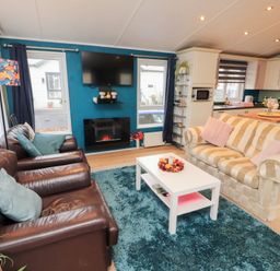 A living room with sofas and a television at Rosie's Zen Den High Hesket near Armathwaite