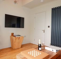 A living room with a television and a wooden stool at Sea View in St Austell