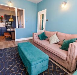 A living room with a sofa and ottoman at The Old Post Office in Weymouth
