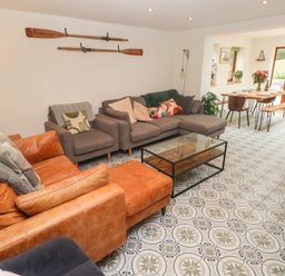A living room with sofas a glass coffee table patterned floor and a dining area at Rudbaxton Water Rudbaxton near Haverfordwest