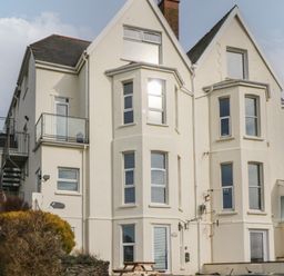 A large white residential building with multiple windows and a balcony at 5 Seymour Villas in Woolacombe