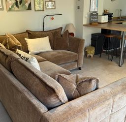 A living room with a sofa and kitchen area at The Annexe in Bridlington