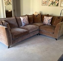A living room with a brown sofa and decorative pillows at The Annexe in Bridlington