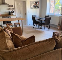 A living room with a sofa and dining area at The Annexe in Bridlington