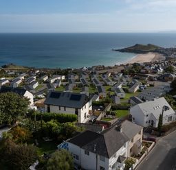 A coastal village with houses and caravans near a beach at Lanyon in St Ives