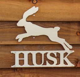 A metal sign shaped like a running hare with the word HUSK mounted on wooden boards at Husk Little Kelk near Bridlington