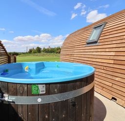 An outdoor hot tub with rubber ducks next to a wooden building at Parliament in Little Kelk near Bridlington