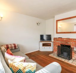 A living room with a sofa, television, and fireplace at 5 Prospect Place in Woodbridge