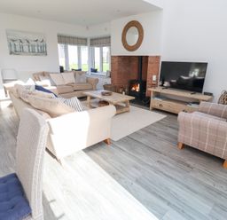 A living room with a sofa and television at The Beach House (Beadnell)