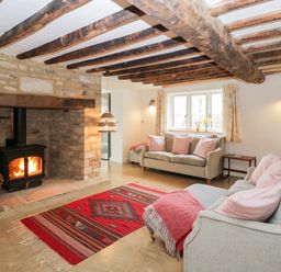 A living room with two sofas and a wood burning stove at High Cogges Farm Holiday Cottages Witney