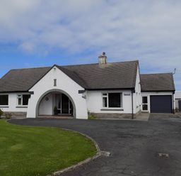 A single-story house with a curved driveway lawn and garage at Brookfield in St Gennys near Wainhouse Corner